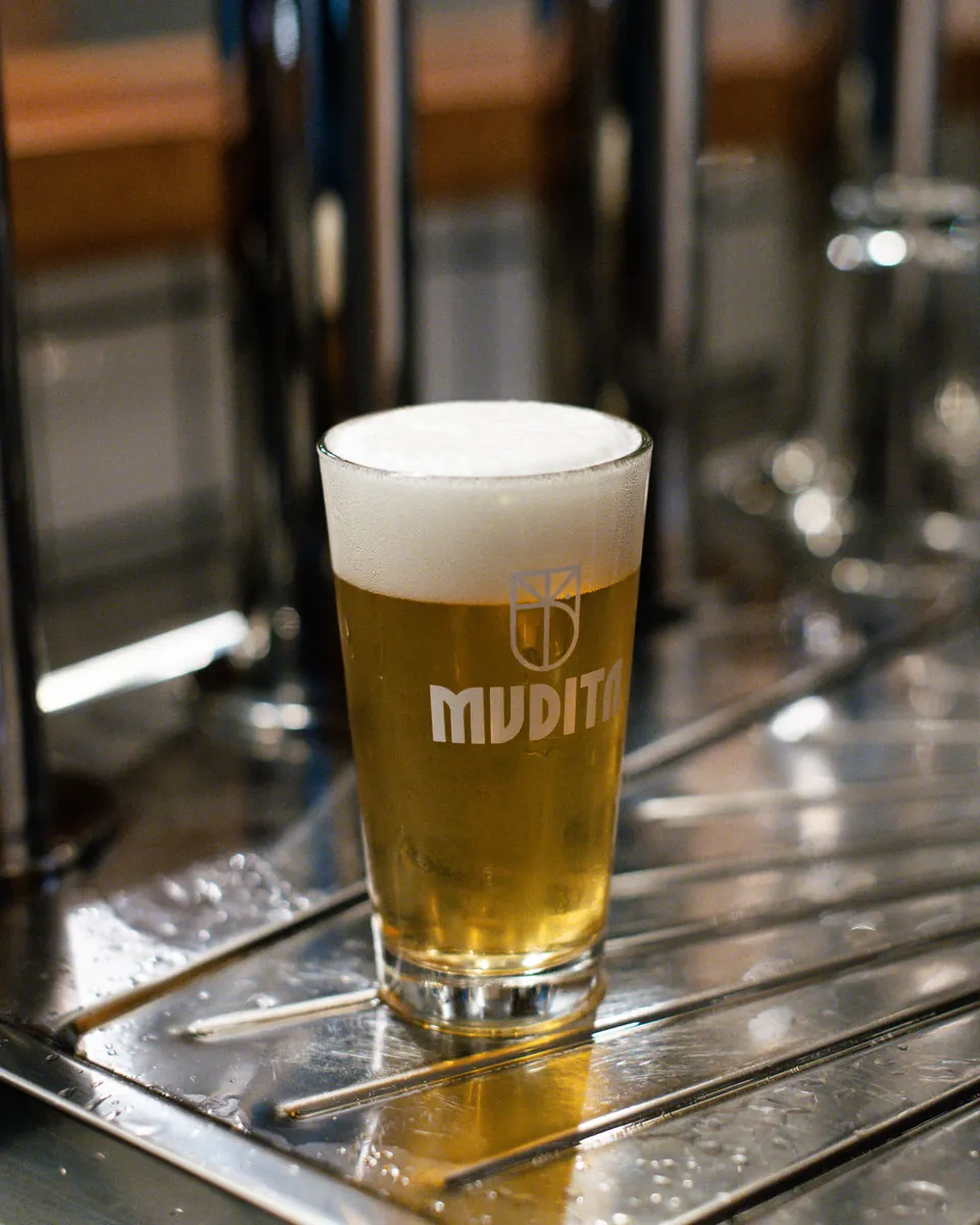 Una pinta di birra Mudita appena spillata sul piano delle spine